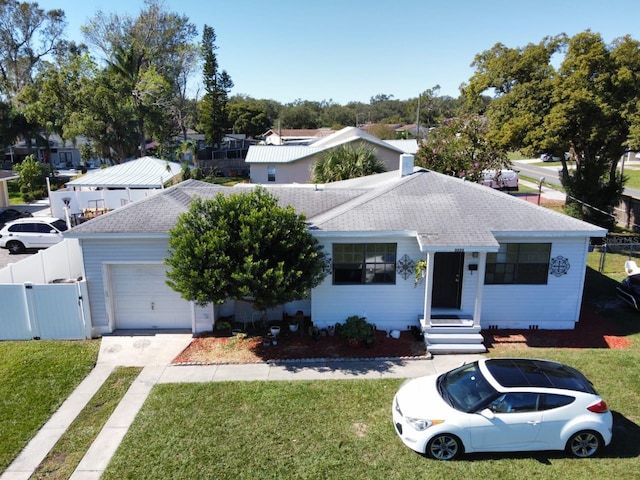 view of front of home with a front yard and a garage