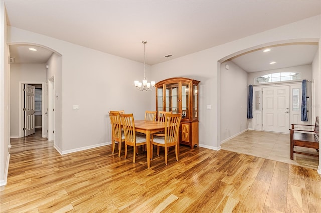 dining room with light wood-type flooring and a chandelier