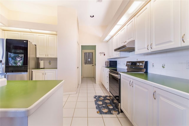 kitchen with light tile patterned floors, tasteful backsplash, lofted ceiling, white cabinets, and appliances with stainless steel finishes