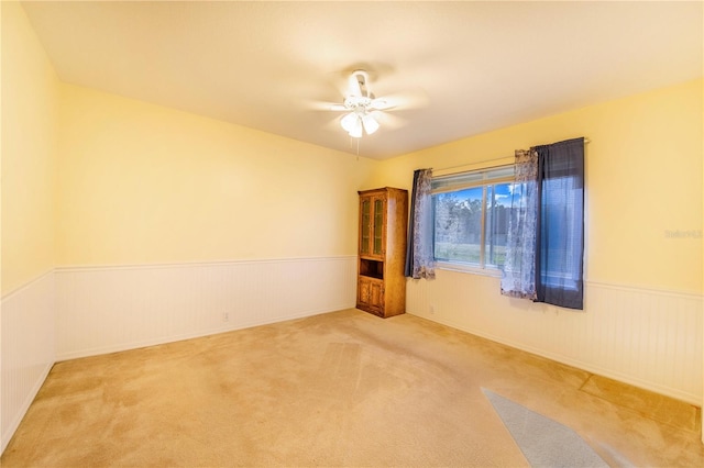 carpeted empty room featuring ceiling fan