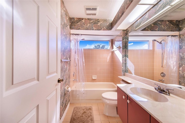 full bathroom with tile patterned flooring, vanity, toilet, and tiled shower / bath combo