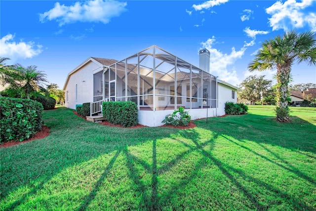 back of house with a lanai and a yard