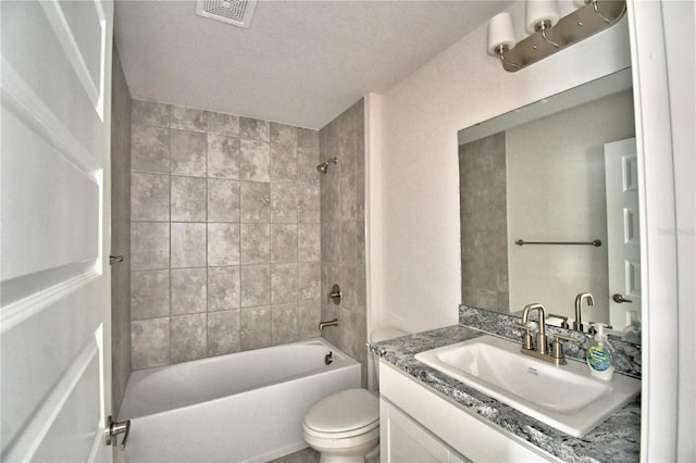 full bathroom featuring tiled shower / bath combo, vanity, and toilet