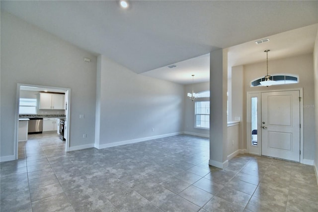 tiled foyer with high vaulted ceiling and a chandelier