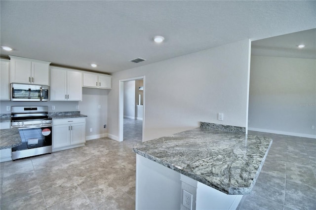 kitchen featuring stainless steel appliances, light stone countertops, white cabinets, and kitchen peninsula