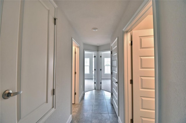 hallway with dark tile patterned floors