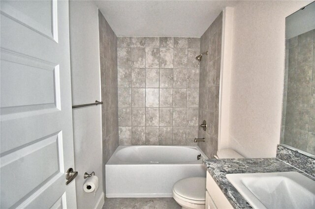 full bathroom with vanity, tiled shower / bath combo, and toilet