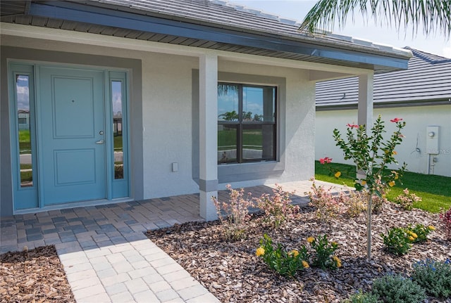 view of exterior entry with a porch