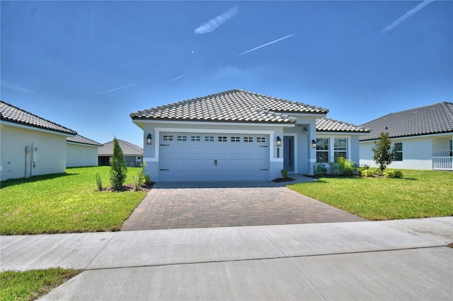 mediterranean / spanish home with stucco siding, decorative driveway, a front lawn, and an attached garage