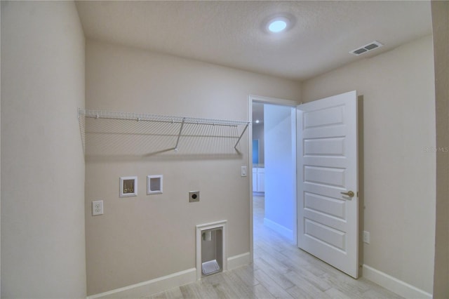 laundry area featuring light wood finished floors, hookup for an electric dryer, laundry area, visible vents, and hookup for a washing machine