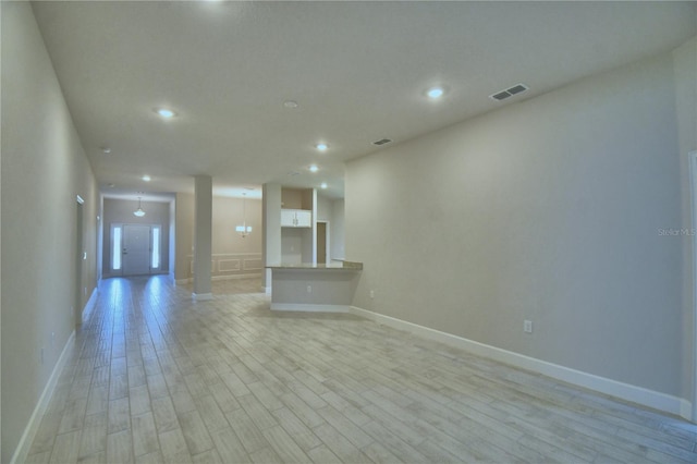 unfurnished living room with light wood-type flooring, recessed lighting, baseboards, and visible vents