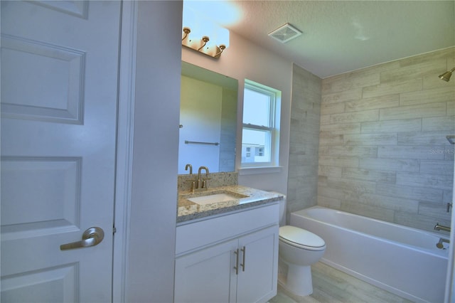 bathroom with visible vents, toilet, wood finished floors, vanity, and shower / bathing tub combination
