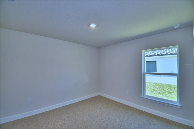 carpeted spare room with baseboards