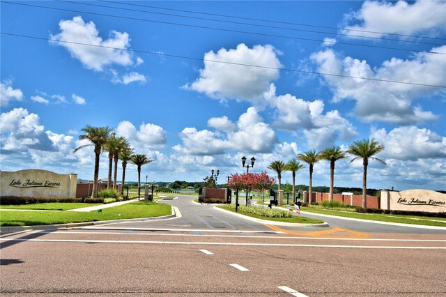 view of street featuring a gated entry and curbs