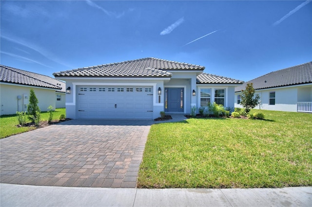 view of front facade with a tile roof, stucco siding, an attached garage, decorative driveway, and a front yard