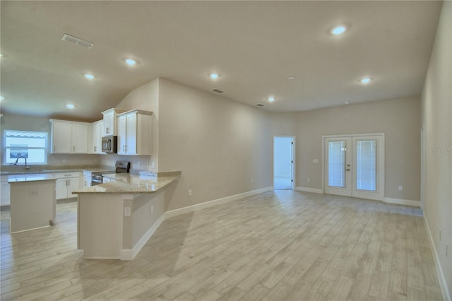 kitchen with visible vents, white cabinets, light wood-type flooring, and stainless steel appliances