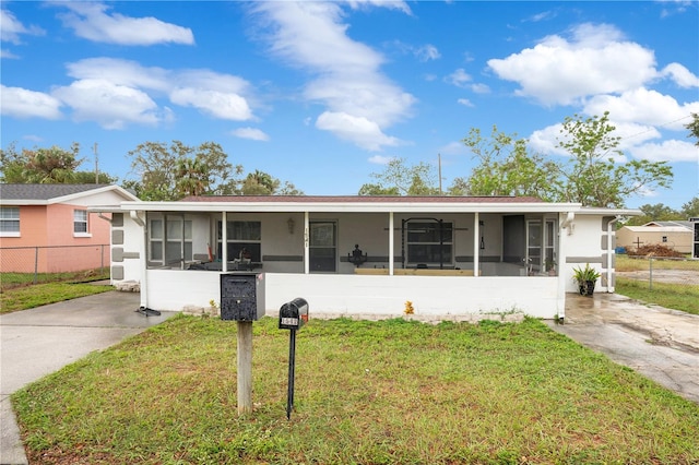 ranch-style home with a front yard and a sunroom