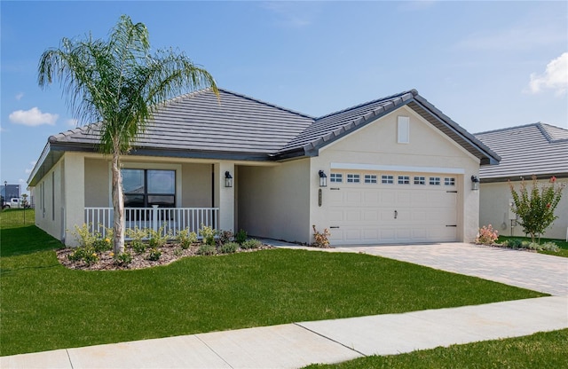 single story home featuring covered porch, a front yard, and a garage