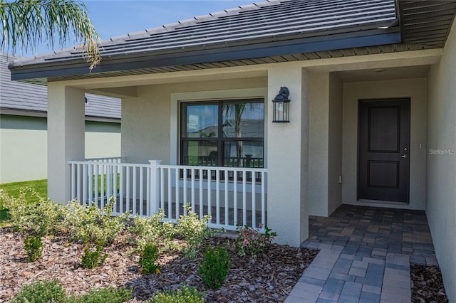 view of exterior entry with a porch