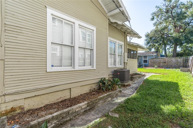 view of side of property with cooling unit and a yard