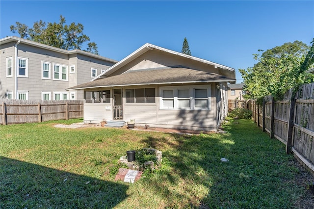 rear view of house featuring a yard