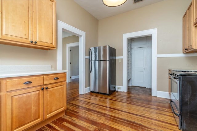 kitchen featuring stainless steel refrigerator, dark hardwood / wood-style floors, and black range with electric cooktop