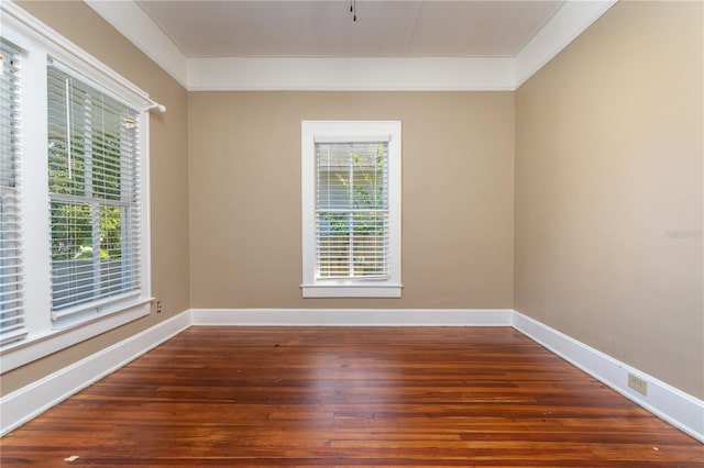 spare room with dark wood-type flooring and ornamental molding