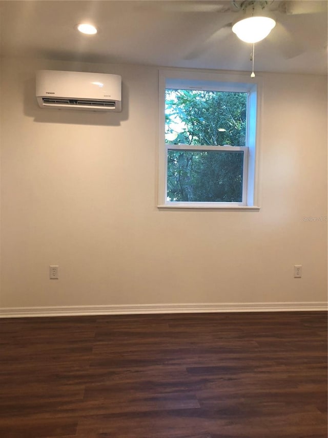 empty room with dark hardwood / wood-style flooring and an AC wall unit