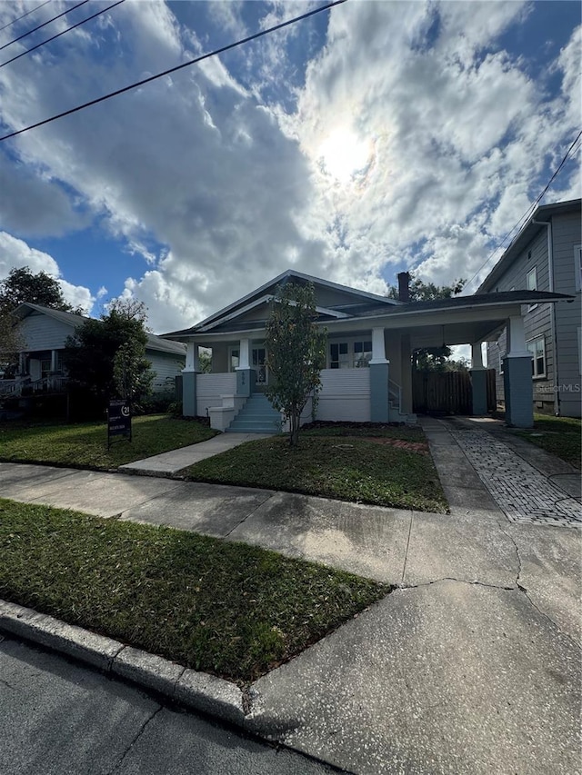 view of front of home featuring a carport and a front lawn