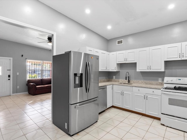 kitchen with sink, light tile patterned floors, ceiling fan, appliances with stainless steel finishes, and white cabinetry