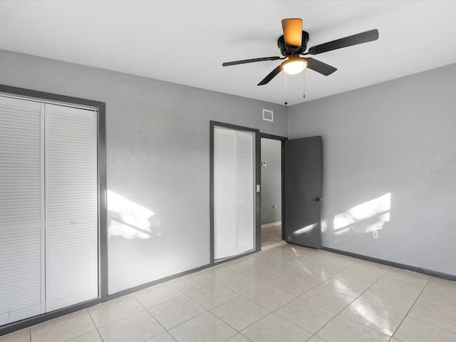 unfurnished bedroom with light tile patterned floors and ceiling fan