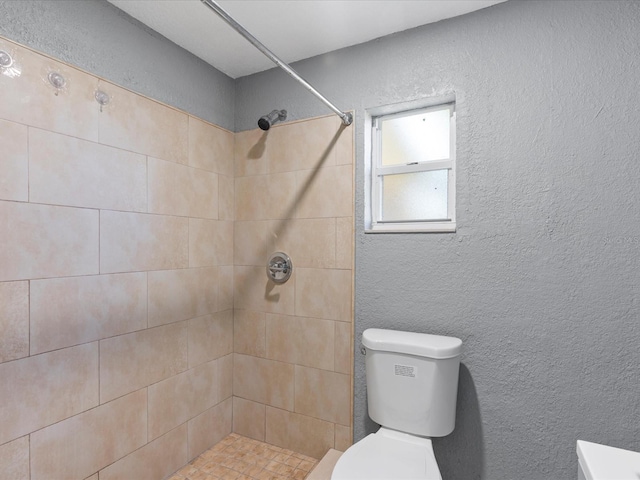 bathroom with toilet and tiled shower