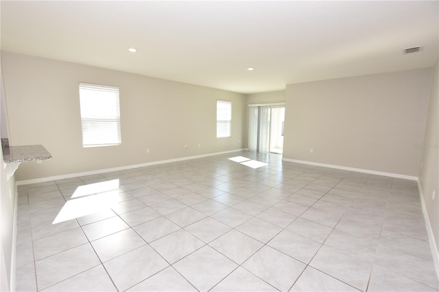 spare room featuring a healthy amount of sunlight and light tile patterned floors