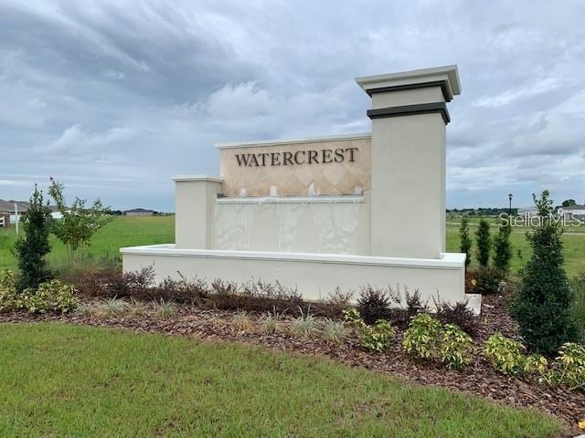 community / neighborhood sign featuring a lawn