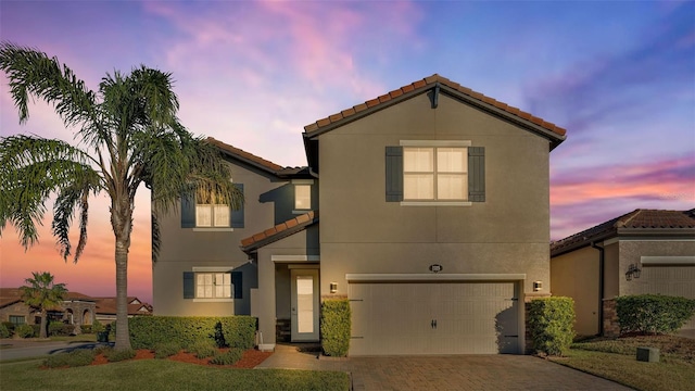 mediterranean / spanish-style home with a garage and a yard