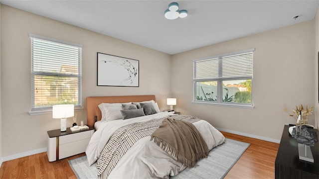 bedroom with multiple windows and light hardwood / wood-style floors