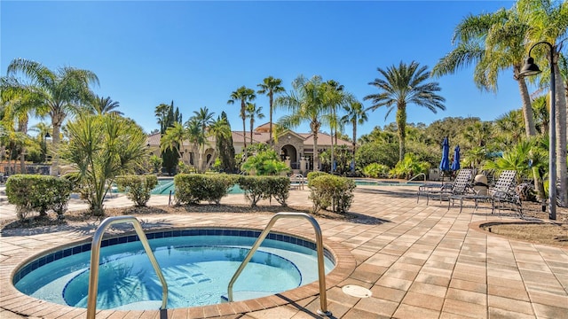 view of swimming pool with a community hot tub and a patio area