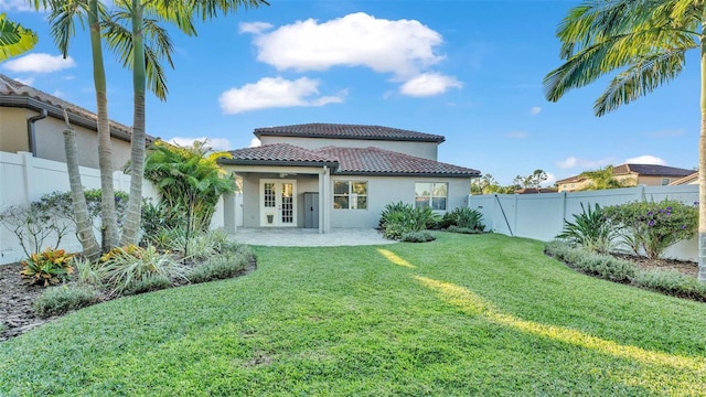 rear view of property featuring a lawn and a patio area