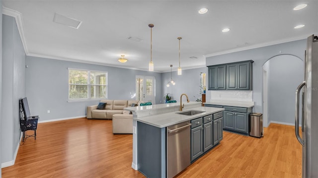 kitchen featuring sink, a kitchen island with sink, pendant lighting, stainless steel appliances, and light hardwood / wood-style floors