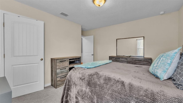 bedroom featuring light carpet and a textured ceiling