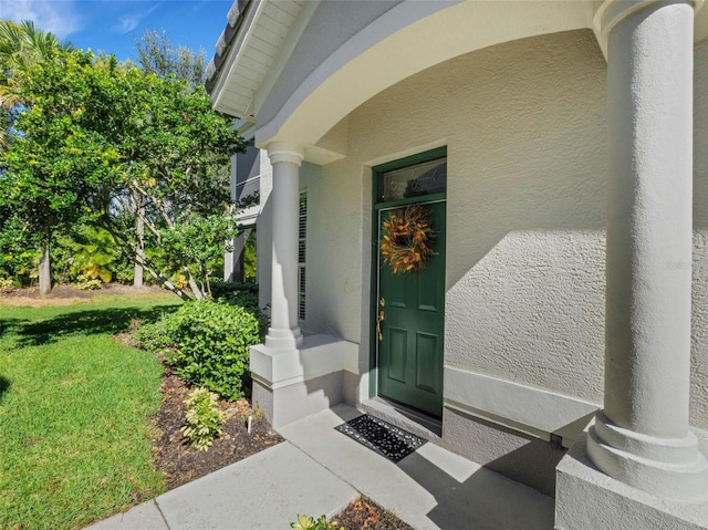 view of exterior entry featuring a yard