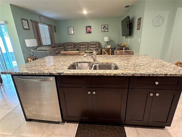 kitchen with dark brown cabinets, light stone counters, stainless steel dishwasher, and sink