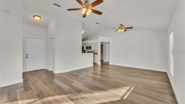 unfurnished living room with a textured ceiling, light wood-type flooring, ceiling fan, and lofted ceiling