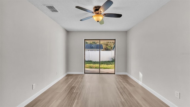 empty room with ceiling fan, a textured ceiling, and light wood-type flooring