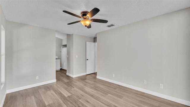 empty room with a textured ceiling, light hardwood / wood-style flooring, and ceiling fan