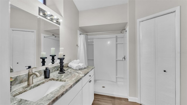 bathroom with curtained shower, hardwood / wood-style floors, and vanity