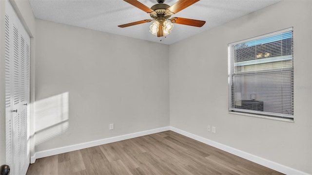 empty room featuring ceiling fan, a textured ceiling, and light wood-type flooring