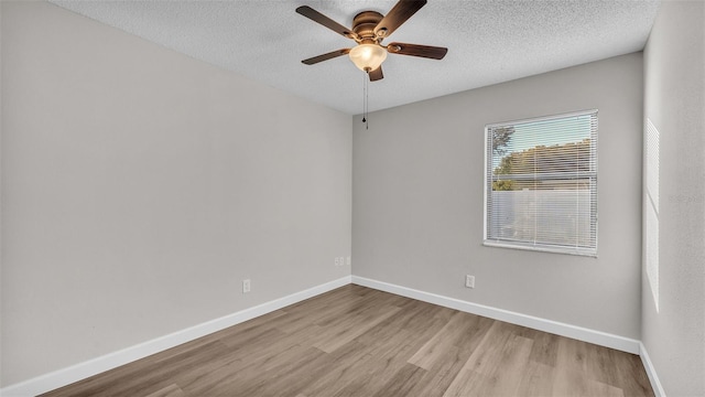 unfurnished room with ceiling fan, a textured ceiling, and light wood-type flooring