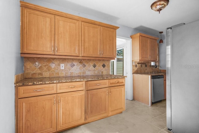 kitchen with stone counters, sink, decorative backsplash, light tile patterned floors, and appliances with stainless steel finishes