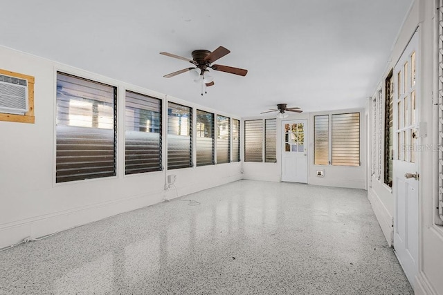 unfurnished sunroom featuring ceiling fan